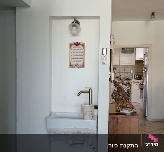 כיור עם ברז זהב בקיר לבן